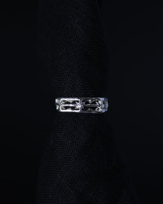 Sterling silver band ring with a unique star design on a black background