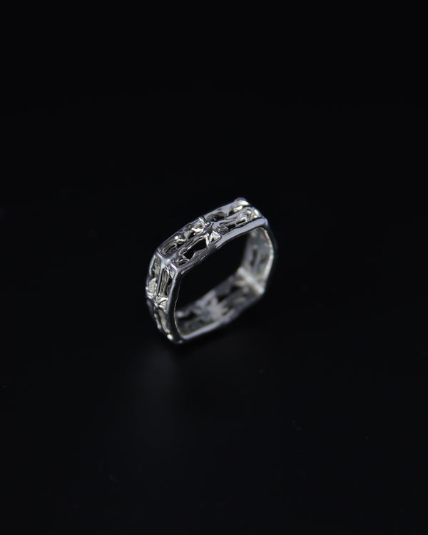 Silver square band ring with intricate star design on a black background