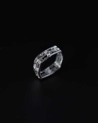 Silver square band ring with intricate star design on a black background