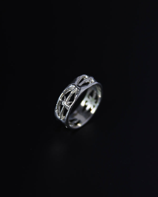 Sterling silver and moissanite ring with intricate star design on a black background