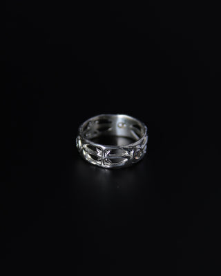 Silver ring with intricate north star design on a black background