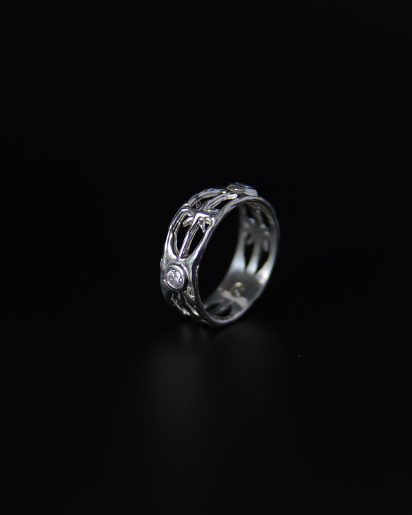 Moissanite silver ring with intricate design on a black background