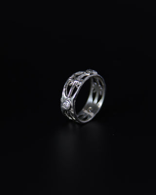 Moissanite silver ring with intricate design on a black background