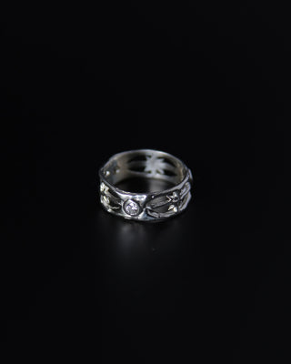 Silver ring with star designs on a black background