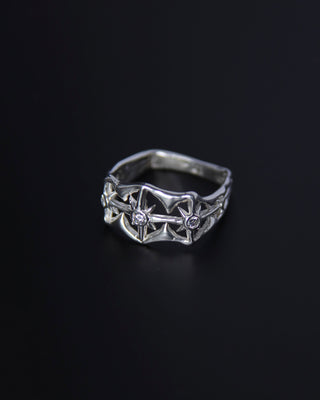 Silver ring with intricate design on a black background