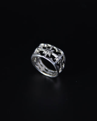 Silver ring with intricate north star design on a black background