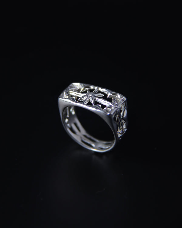 Sterling silver signet ring with intricate stardesign on a black background