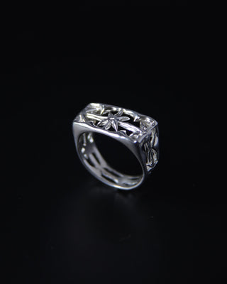 Sterling silver signet ring with intricate stardesign on a black background