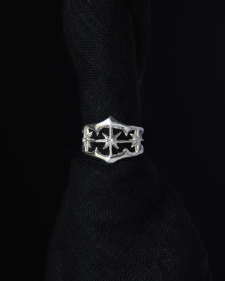 Silver band ring with star design on a black background