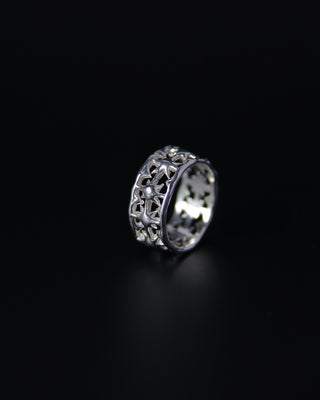 Silver ring with intricate star design on a black background