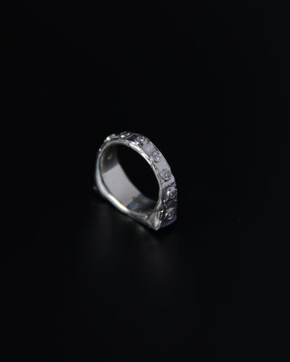 Sterling silver signet ring with embedded stones on a black background
