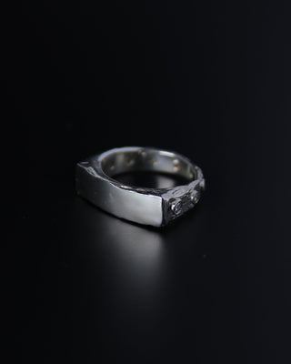 Sterling silver signet ring with moissanite stones on a black background