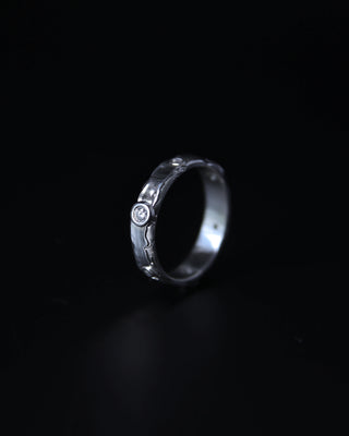 Sterling silver ring with intricate design on a black background