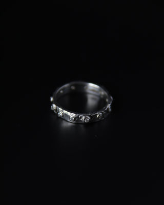 Sterling silver molten texture ring with diamond like stones on a black background